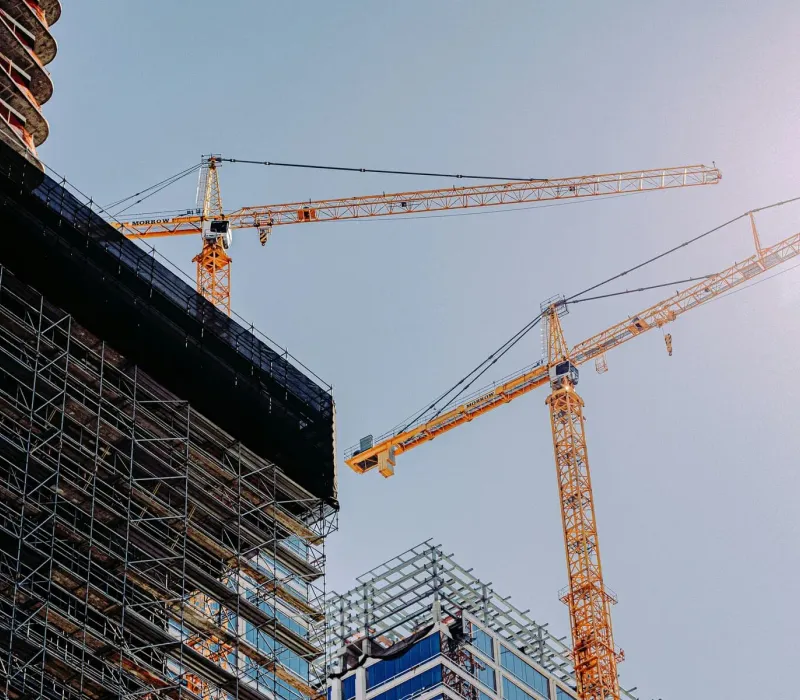 Tower cranes and scaffolding on an active construction project at golden hour