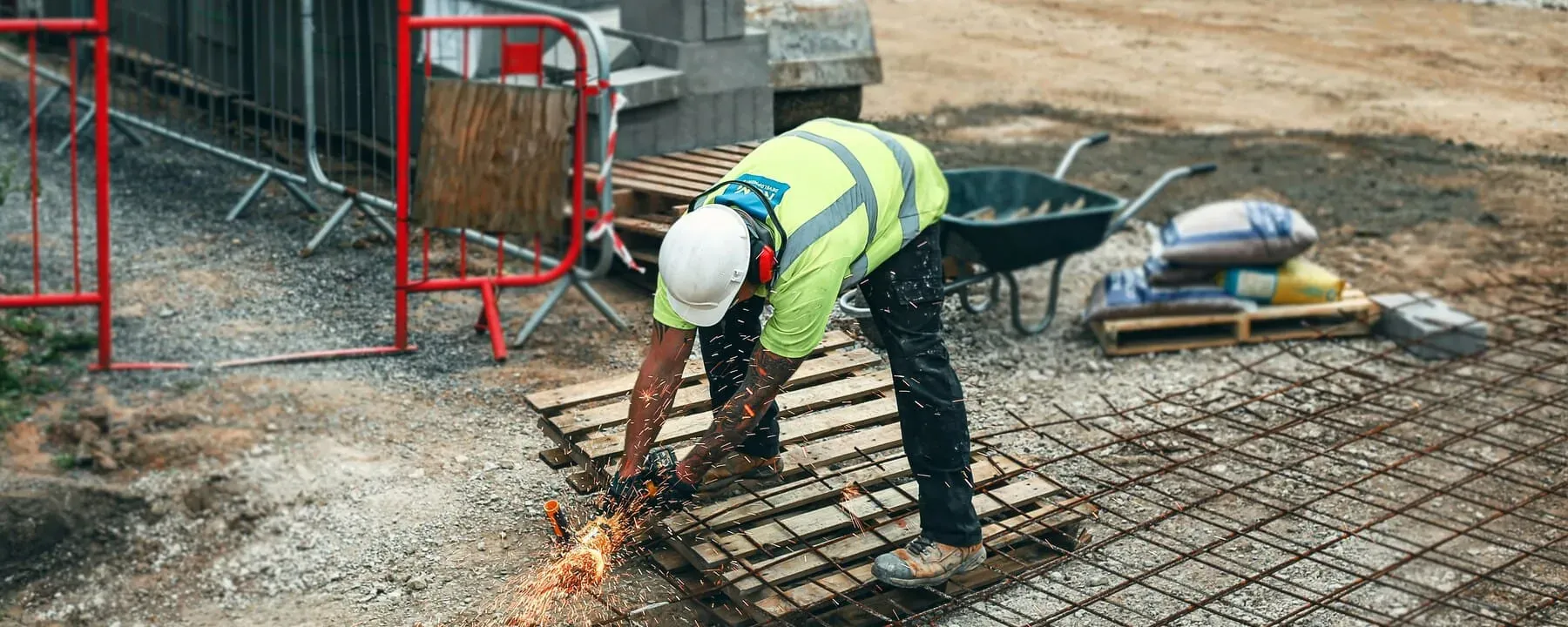 Construction worker performing on-site metal cutting during field support