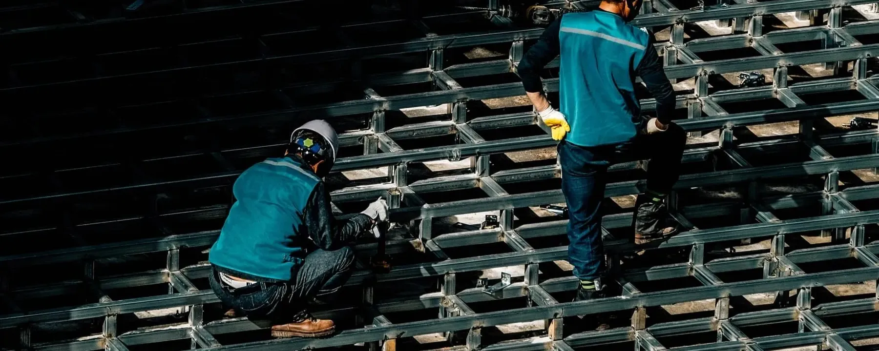 Workers placing and inspecting steel reinforcement on a construction deck